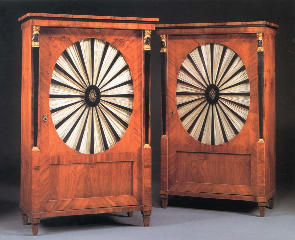 19th Century AUSTRIAN, Pair of Biedermeier Gilt-Metal-Mounted Black Walnut, Ebonized and Parcel Gilt Cabinets, 1800-1825
Mixed woods, 66 1/2 x 40 1/8 x 21 in. (168.9 x 101.9 x 53.3 cm)
Each with a molded cornice above the cabinet door centered by an oval, glazed panel with radiating ebonized splats centered by a pierced oval mount opening to reveal shelves, flanked by military terminal supports raised on square tapering feet, now fitted with silk fabric.
BIE-002-FU
$42,000